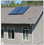 Close-up photo of a residential building roof with two solar panels.  